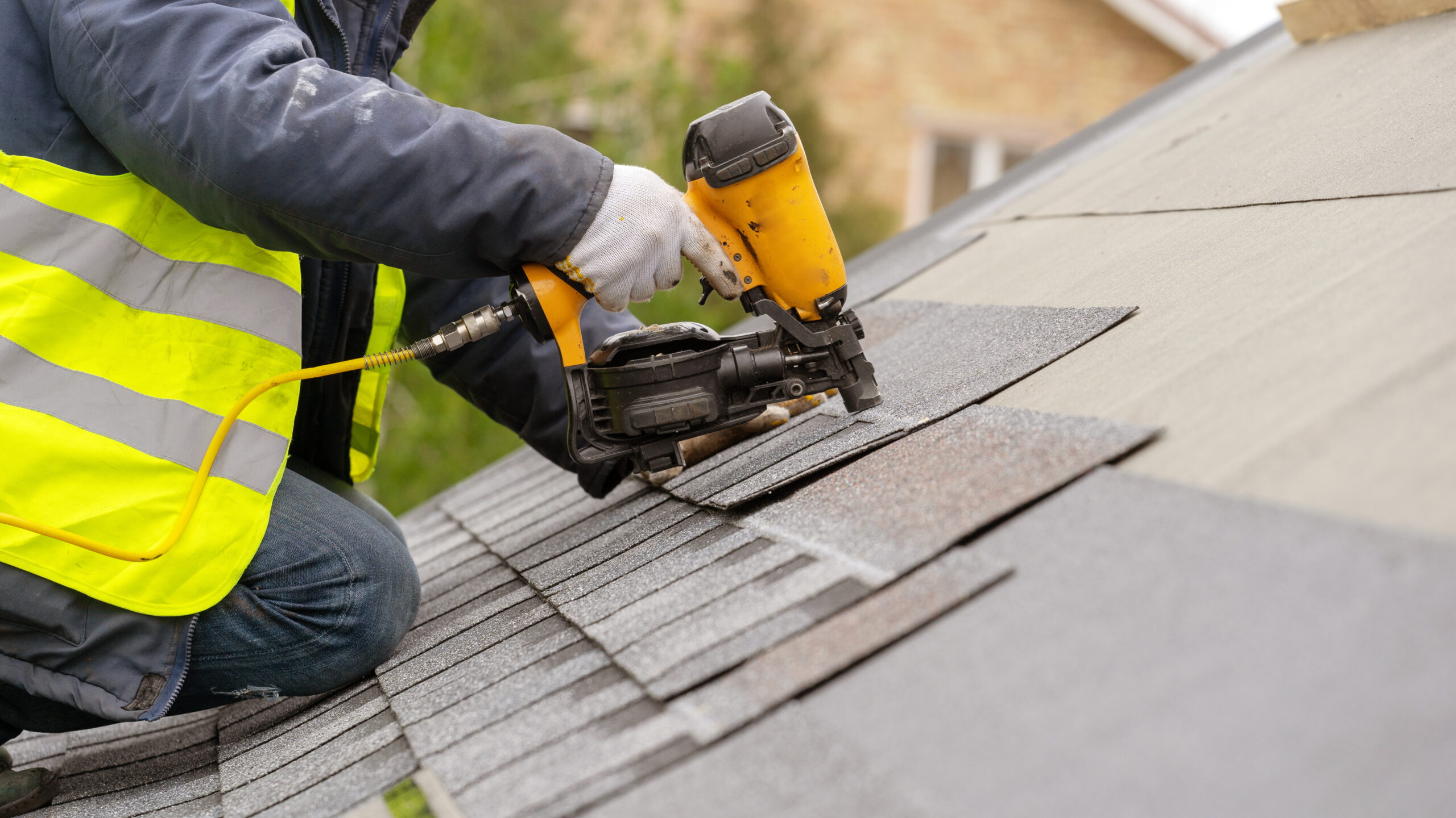 Roofer installing shingle on roof